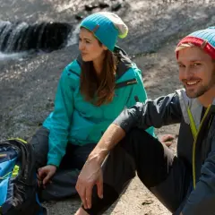 Para, odpoczywająca nad strumieniem po udanym trekkingu. To właśnie jest trekking – przygoda na łonie natury.